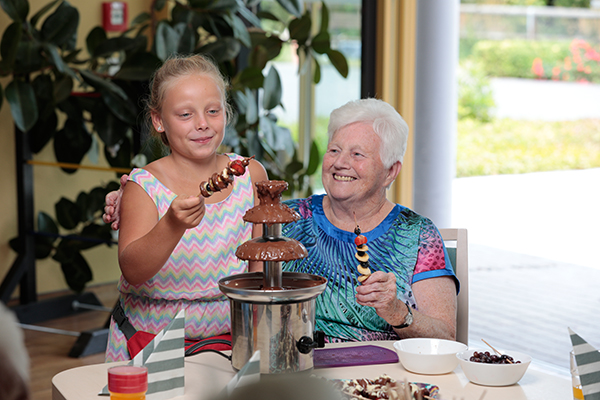 Kind, Seniorin und Schokobrunnen